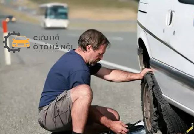 Tài xế đang kiểm tra bánh xe sau khi phát hiện xe bị thủng lốp giữa cao tốc Tài xế đang kiểm tra bánh xe sau khi phát hiện xe bị thủng lốp giữa cao tốc