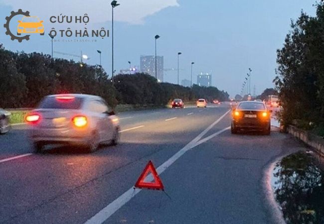 Hình ảnh một chiếc xe chết máy giữa đường cao tốc vào ban đêm, đang bật đèn cảnh báo nguy hiểm và dừng đúng quy định. Hình ảnh một chiếc xe chết máy giữa đường cao tốc vào ban đêm, đang bật đèn cảnh báo nguy hiểm và dừng đúng quy định.
