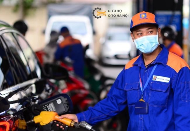 Nhân viên cứu hộ xăng dầu đang thực hiện dịch vụ đổ xăng tận nơi tại Hà Nội vào ban đêm.